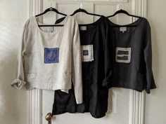 two black and white shirts hanging on a door