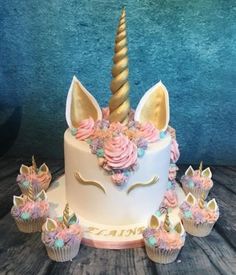 a birthday cake decorated with flowers and a unicorn's horn