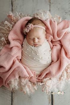 a newborn girl is wrapped in pink blanket