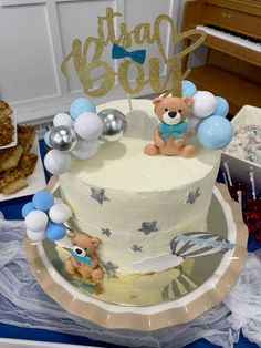 a birthday cake decorated with teddy bears and balloons on a table next to other desserts