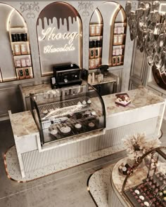 a display case in a bakery filled with cakes and cupcakes next to a chandelier