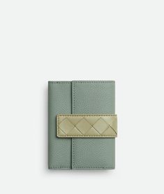 "Find BOTTEGA VENETA Tag Tri-fold Zip Wallet on Editorialist. Six card slots, one note compartment, two additional pockets, one zipped coin purse. Intrecciato leather tab closure with snap button. Lining: Calfskin. Color: New Sauge/Travertine/Kaki. Hardware: Gold finish. Height: 9 cm | 16.9\". Width: 11.5 cm | 16.9\". Depth: 2 cm | 0.8\". Calfskin." Green Leather Luxury Card Holder, Luxury Green Leather Card Holder, Elegant Green Bifold Card Holder, Green Leather Evening Wallets, Luxury Green Bifold Wallet, Elegant Green Bifold Wallet, Elegant Green Coin Purse For Travel, Elegant Green Wallets For Travel, Designer Green Wallet With Interior Card Slots