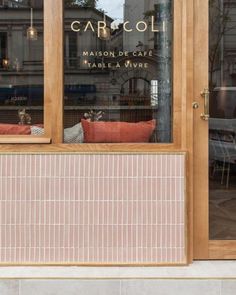 a cat sitting in the window of a cafe