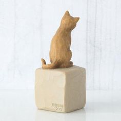 a cat figurine sitting on top of a block