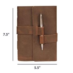 a brown leather notebook with a pen in the pocket and measurements for each page on it