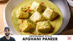 a man sitting in front of a plate of food with tofu and sauce on it