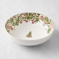 a white bowl with holly and berries on it