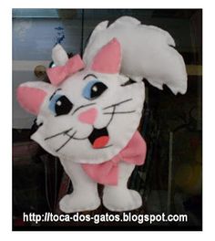 a white cat stuffed animal with a pink bow around its neck