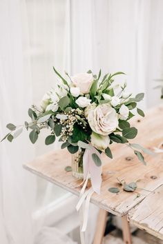 a bouquet of flowers sitting on top of a wooden table