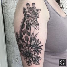 a giraffe and flowers tattoo on the arm