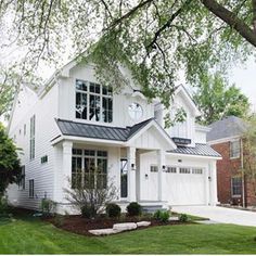 a large white house with a clock on it's face and two story windows