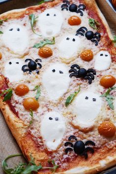 a pizza topped with cheese and black olives in a cardboard box on top of a table