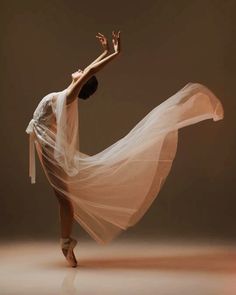 a woman in white dress and veil dancing