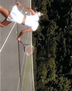 a female tennis player in action on the court with her racquet raised up