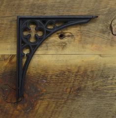 an iron shelf bracket on the side of a wooden wall