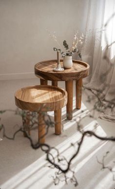 two small wooden tables sitting next to each other on top of a white carpeted floor