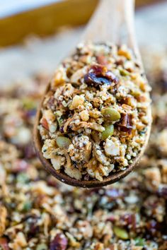 a wooden spoon filled with granola and nuts