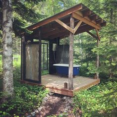 a blue bath tub sitting on top of a wooden platform in the middle of a forest