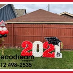 a graduation yard decoration with balloons and decorations in the shape of letters that read 2012