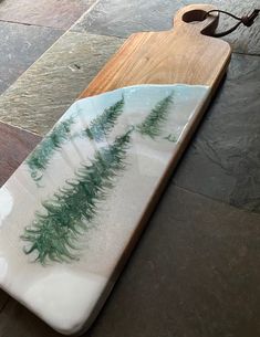 a white plate with green plants on it sitting on a wooden tray next to a pair of glasses