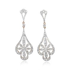 A pair of Edwardian-style dangling earrings centering two bezel-set transitional cut diamonds weighing approximately 0.12 carats each. The center stones are each surrounded by a floral design set with single cut diamonds. The total weight of the additional diamonds on each earring is approximately 0.47 carats. These earrings are platinum on 18k yellow gold.
These earrings are approximately 5.10cm in length.
If you have any questions about the Corringham earrings, please feel free to contact us. Fine Jewelry Diamond Chandelier Earrings, Diamond Chandelier Earrings For Pierced Ears, Exquisite Diamond Pierced Earrings For Formal Occasions, Exquisite Pierced Diamond Earrings For Formal Occasions, Exquisite Bridal Drop Earrings With Diamond Accents, Formal Teardrop Single Cut Diamond Earrings, Classic Diamond White Pierced Earrings, Classic Diamond Earrings With Elegant Design, Formal Diamond Earrings, Pierced