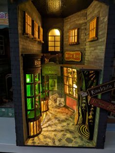 an open door to a dollhouse with lights on and the entrance is lit up