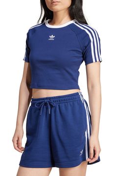 a woman in blue shorts and adidas shirt