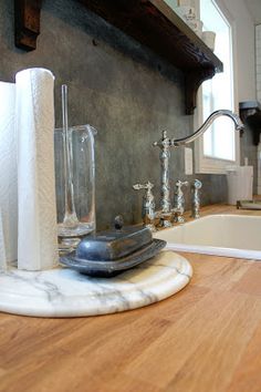 a kitchen counter top with various items on it and a sink in the back ground