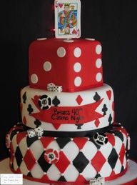 a three tiered cake decorated with red and white checkered, playing cards on top