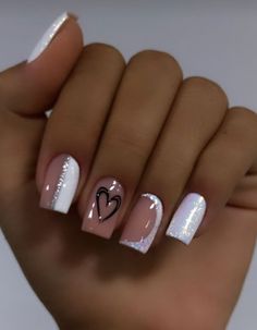 a woman's hand with white and pink nail polishes on her nails, holding a heart shaped manicure