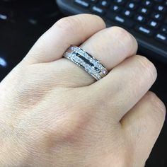 a person's hand with a ring on top of their finger next to a keyboard