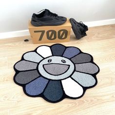 a black and white flower rug on the floor next to a pair of tennis shoes