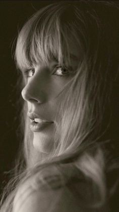 a black and white photo of a woman with long hair looking off to the side