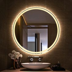 a bathroom sink with a round mirror above it