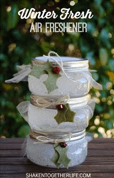 four jars filled with air freshener sitting on top of a wooden table