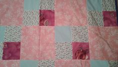 a pink and blue patchwork quilt with flowers on it