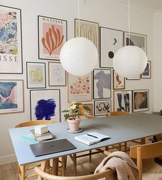 a dining room table with chairs and pictures on the wall