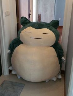 a large stuffed animal sitting on top of a floor next to an open hallway door