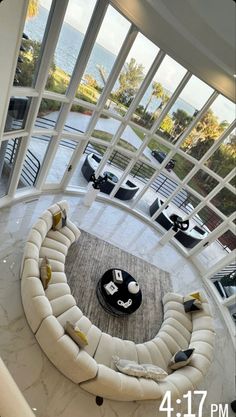 a living room filled with furniture and large windows