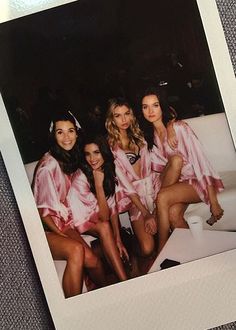 three women in pink robes posing for a photo together with one another on the couch