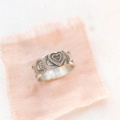 As sweet as could be. A little intricate heart is set on a stamped silver band. Versatile enough to stack with others or wear alone. 7.5 mm wide. Choose your ring size during checkout. Because this is a band ring, we recommend ordering a 1/2 size larger. The design is hand stamped, so slight variations will occur. Sterling silver. Your jewelry will arrive beautifully gift wrapped in a small box. Multiple items will be combined, unless separate boxes are requested. If this is a gift being shipped directly to the recipient, please let me know. I will be glad to include a note from you. Your jewelry will arrive beautifully gift wrapped in a small box. Multiple items will be combined, unless separate boxes are requested. If this is a gift being shipped directly to the recipient, please let me Unique Stamped Jewelry For Promise, Sterling Silver Heart-shaped Engraved Promise Ring, Heart-shaped Sterling Silver Engraved Promise Ring, Promise Engraved Heart Ring In Sterling Silver, Sterling Silver Heart-shaped Engraved Ring, Heart-shaped Sterling Silver Engraved Ring, Sterling Silver Heirloom Heart Ring For Promise, Heirloom Sterling Silver Heart Ring For Promise, Bohemian Sterling Silver Engraved Promise Ring