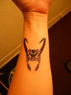 a tattoo on the wrist of a person with an animal head in it's center