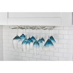 there are five blue cups hanging from the rack on the wall next to the stove