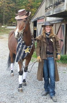 a woman standing next to a brown horse