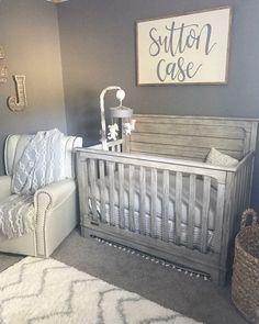 a baby's room with gray walls and white furniture