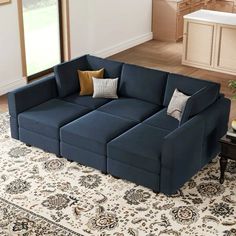 a blue sectional sofa sitting on top of a rug in a living room next to a window