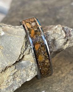 a couple of rings sitting on top of a rock next to a pile of rocks