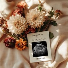 flowers are laying on top of a sheet with a card that says, one more to alive