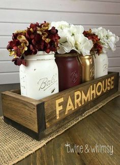 mason jars with flowers in them are sitting on a wooden tray that says farmhouse, and is