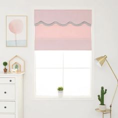 a white room with pink and grey shades on the window sill, potted cacti and cactus